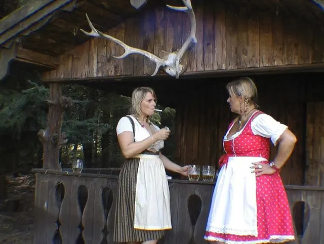 2 Girls im Dirndl die Rauchen und Quatschen.